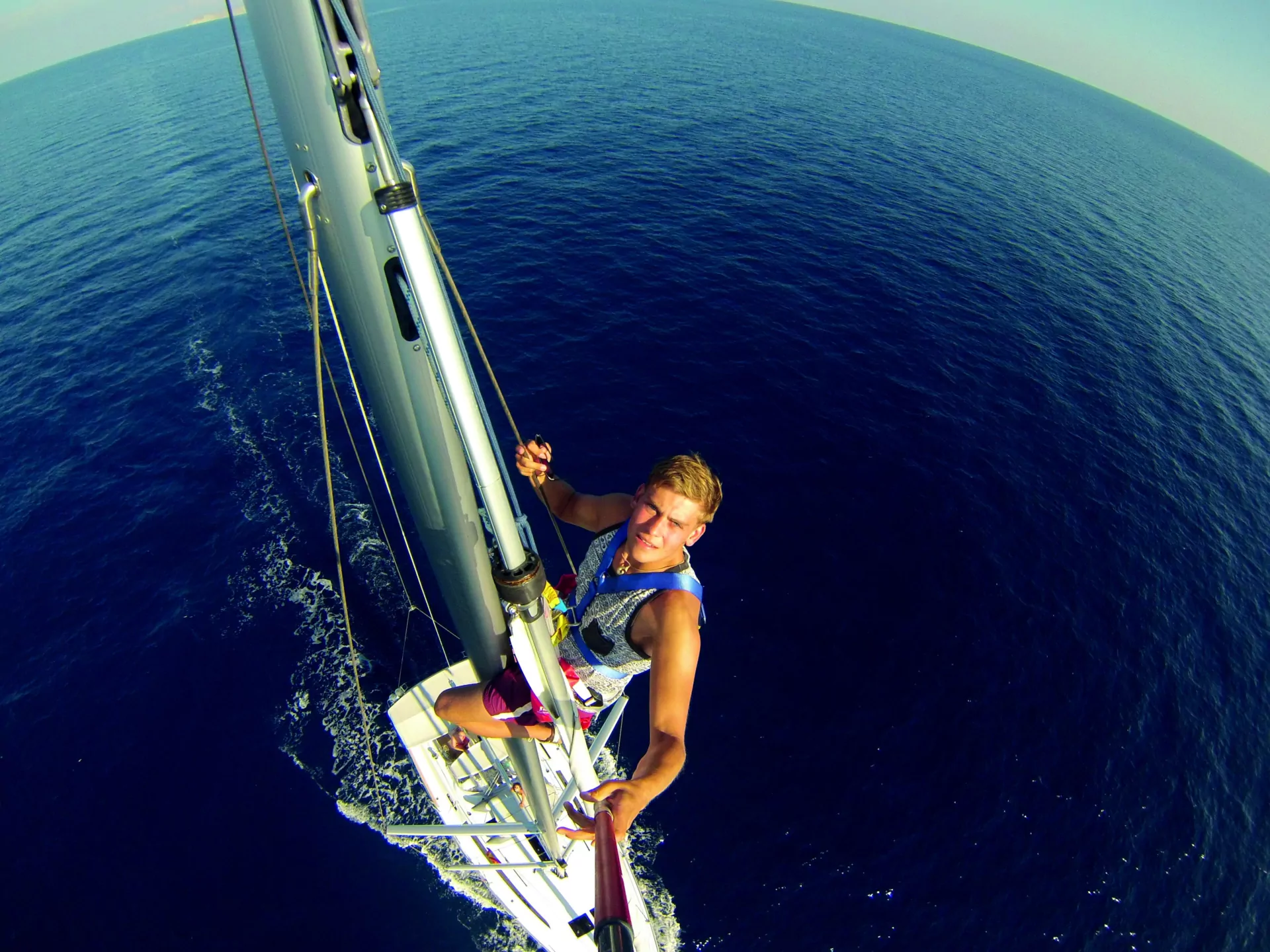 Segelboot-Selfie: Person am Mast über tiefblauem, ruhigem Meer – Segeln, offene See, Aussicht